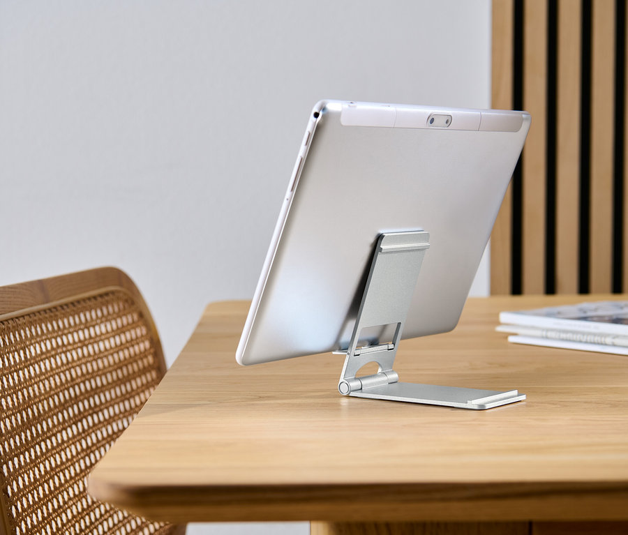 Tablet angelehnt an Smartphone-und-Tablet-Ständer auf Holztisch.
