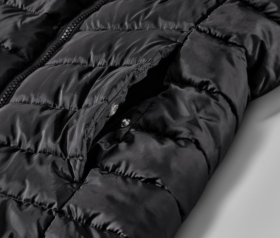 Detailaufnahme einer schwarzen Steppweste mit Tasche.