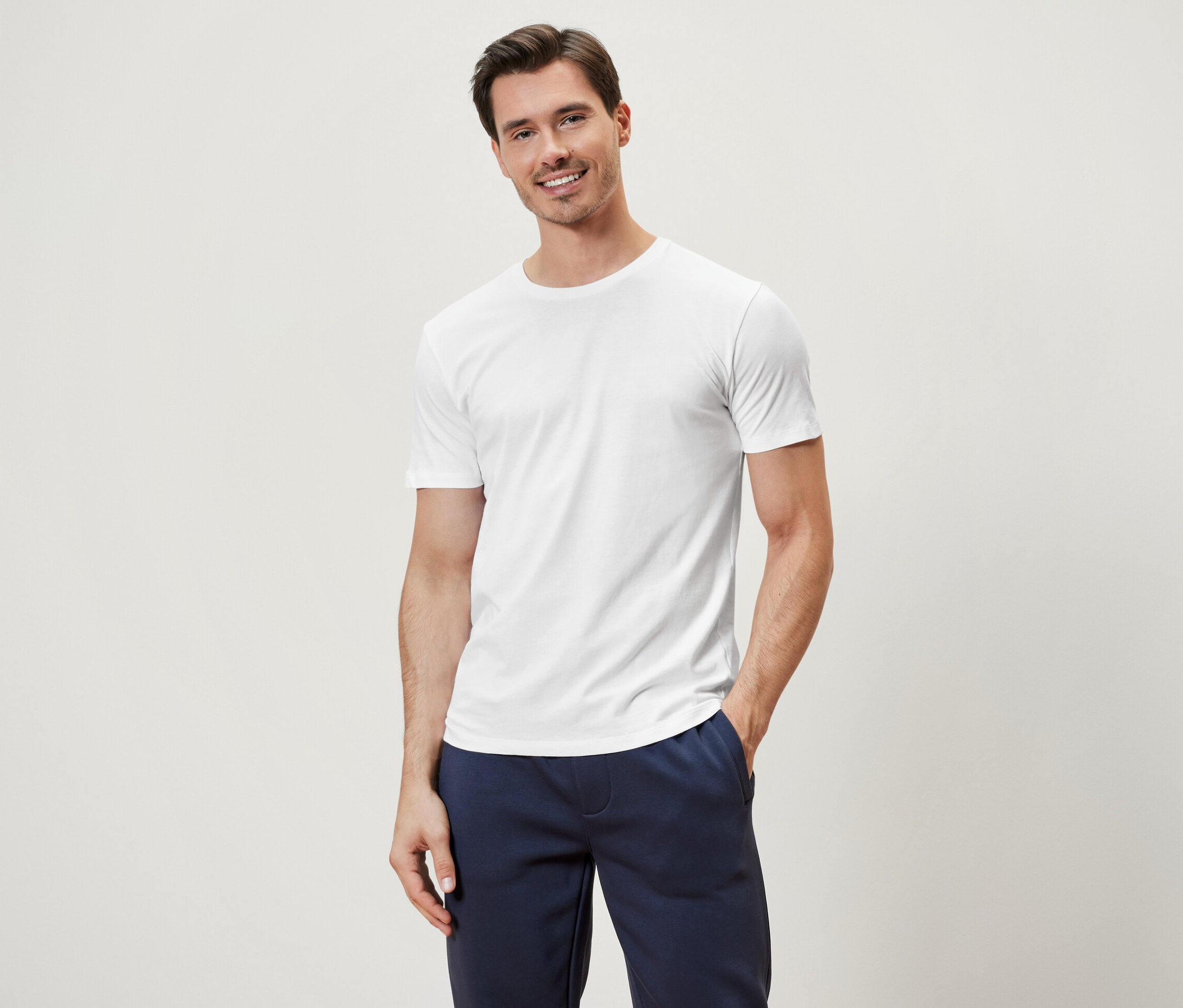 Mann posiert in einem weißen 3 T-Shirts mit Rundhalsausschnitt.