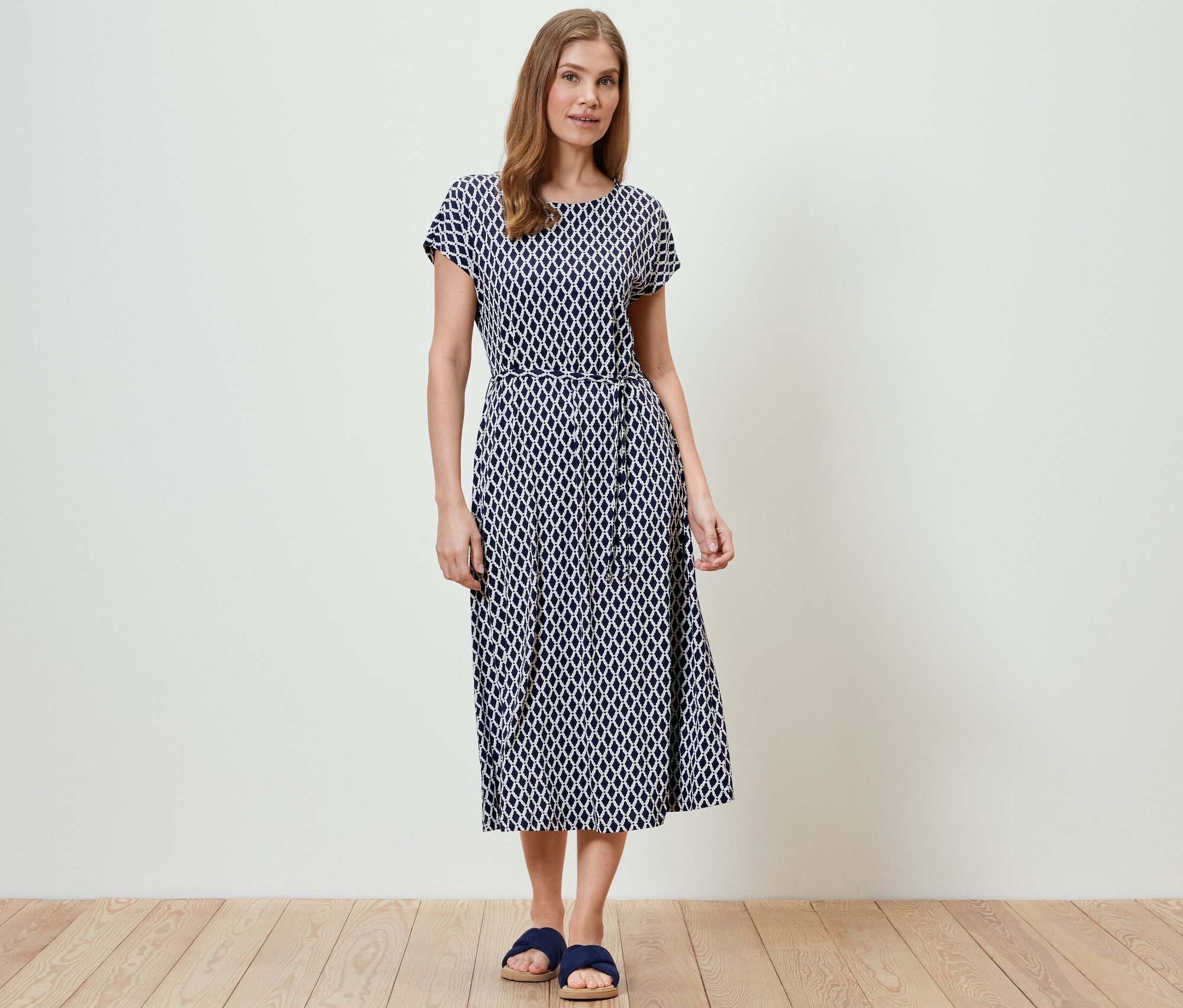 Frau steht und trägt ein bedrucktes Jerseykleid.