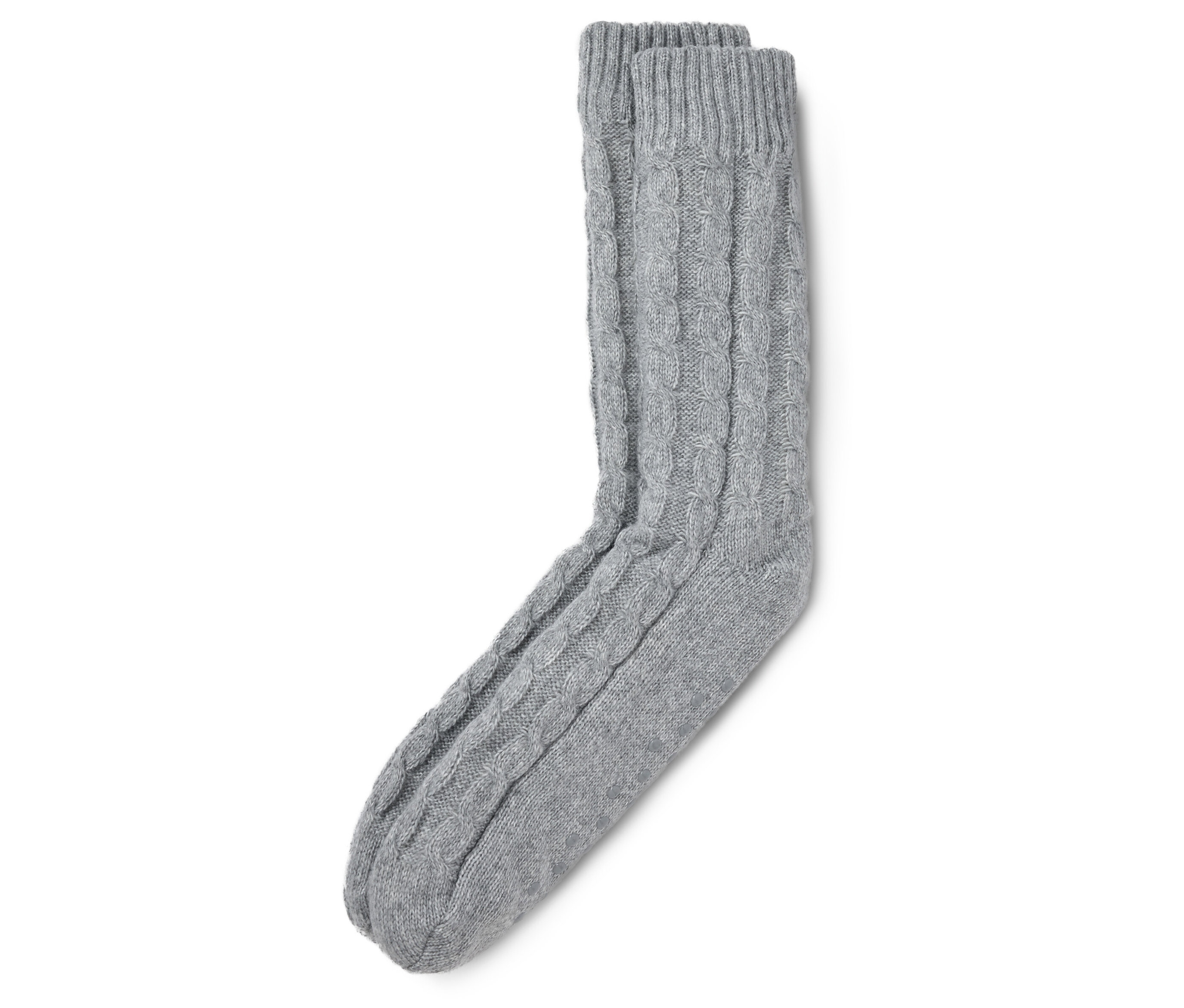 Graue Hausschuhsocken mit Zopfmuster liegen auf einem weißen Hintergrund.