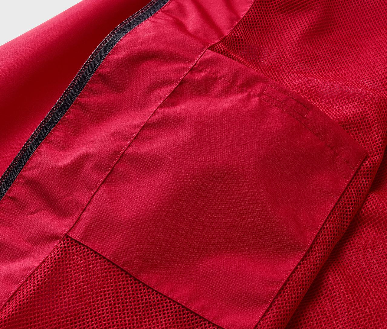 Detailaufnahme einer roten Regenjacke mit Tasche.
