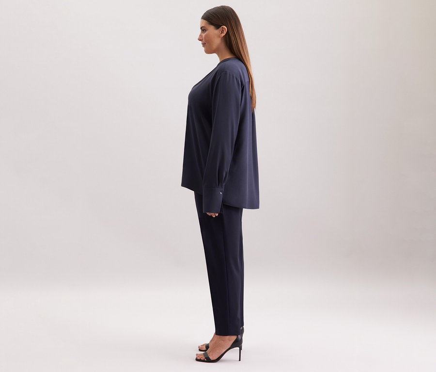 Frau im marineblauen Viskose-Tunika-Hosen-Set von Seidensticker, seitliche Ansicht.