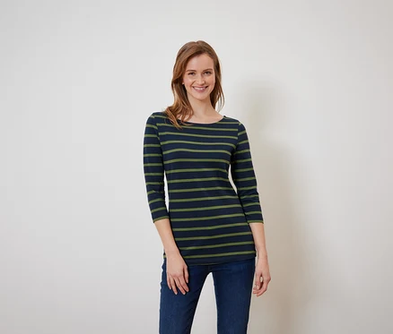 Frau mit braunen Haaren posiert in einem blaugrün gestreiften T-Shirt und blauen Jeans.