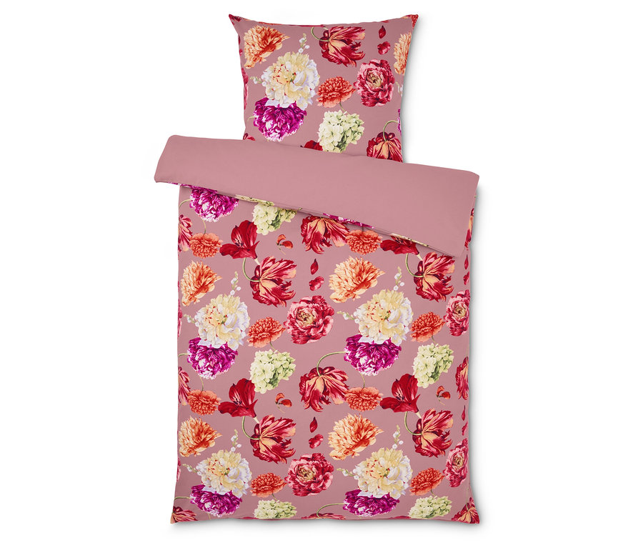 Bettwäsche mit Blumenmuster auf rosa Hintergrund.