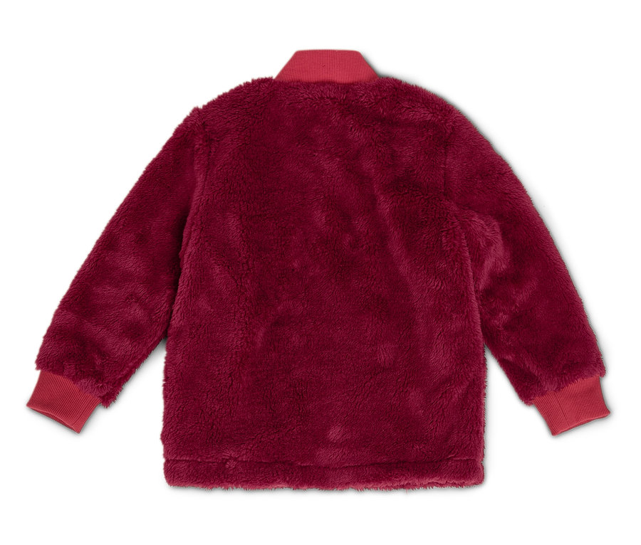 Eine burgunderfarbene, flauschige Jacke mit roten Rippbündchen und Kragen liegt auf einem weißen Hintergrund.
