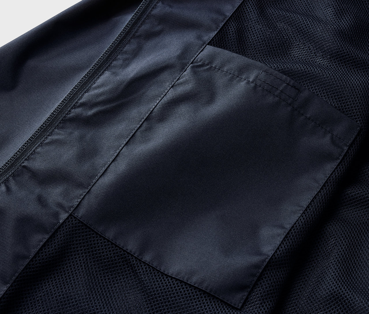 Detailaufnahme einer navy Regenjacke mit Tasche.