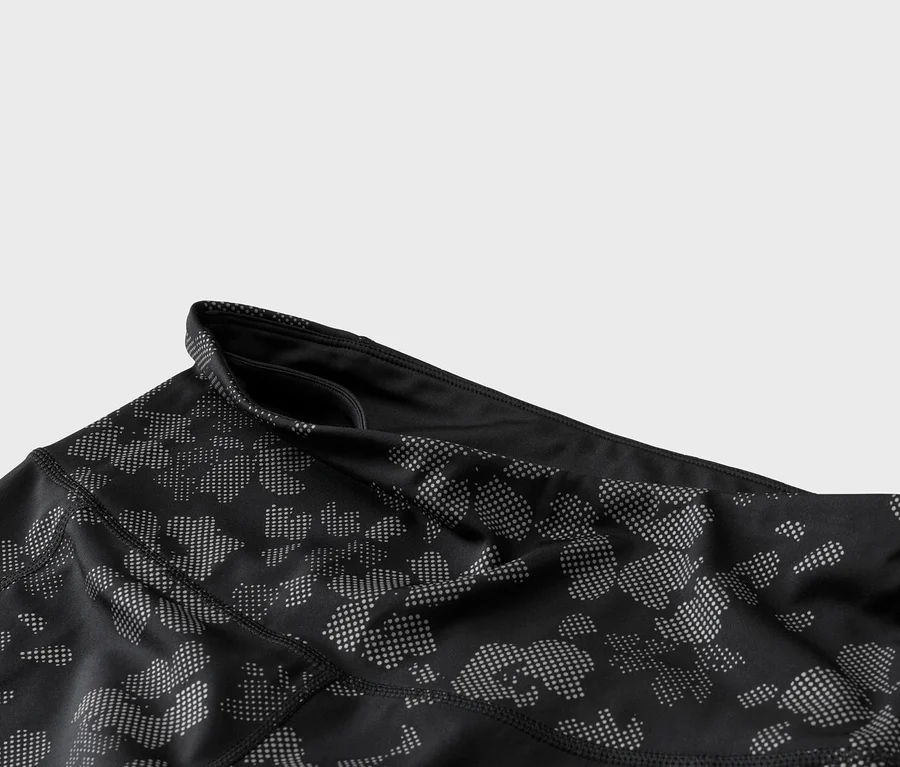 Detailaufnahme von schwarzen Leggings mit einem Muster aus grauen Punkten und einem Bund mit einer kleinen Tasche.