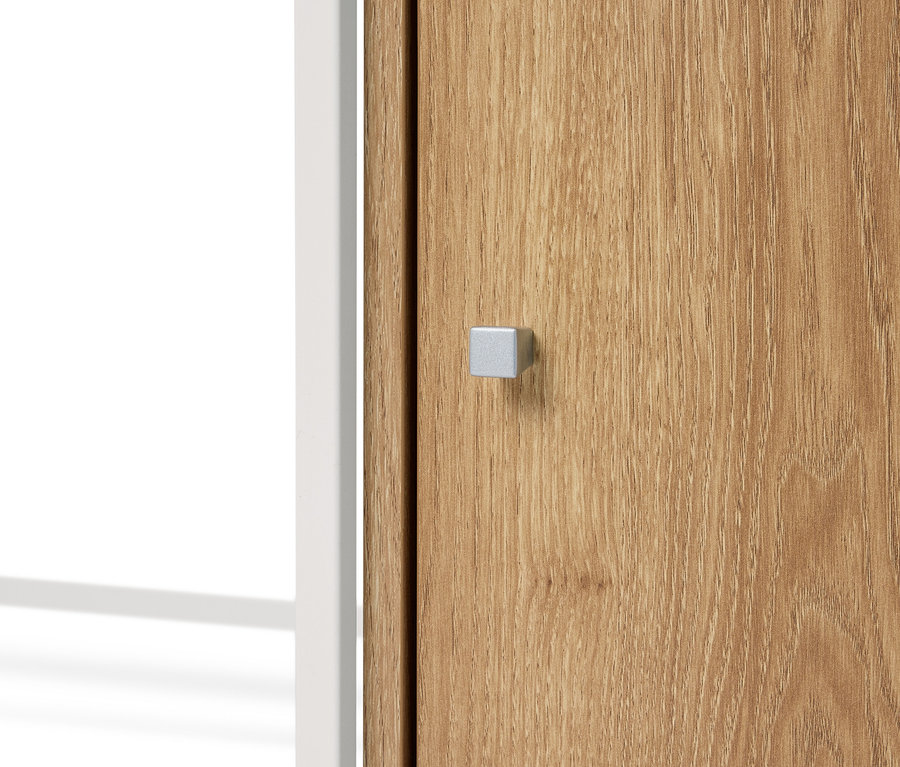 Nahaufnahme einer Holztür mit einem silbernen, quadratischen Griff und einem weißen Rahmen.