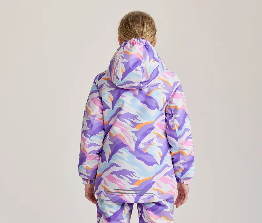 Person von hinten in einer Kapuzenjacke und passender Hose mit farbenfrohem, abstraktem Muster in Lila, Blau, Rosa, Orange und Weiß.