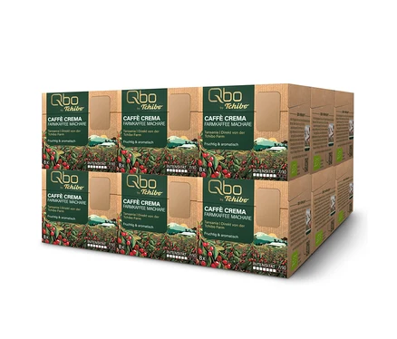 Ein Stapel brauner Qbo Caffè Crema FARMKAFFEE MACHARE Kapselpackungen. Jede Box enthält 8 Kapseln und zeigt Kaffeepflanzen, den Text "Qbo by Tchibo", "Tansania | Direkt von der Tchibo Farm", "Fruchtig & aromatisch" und "Intensität 7/10".