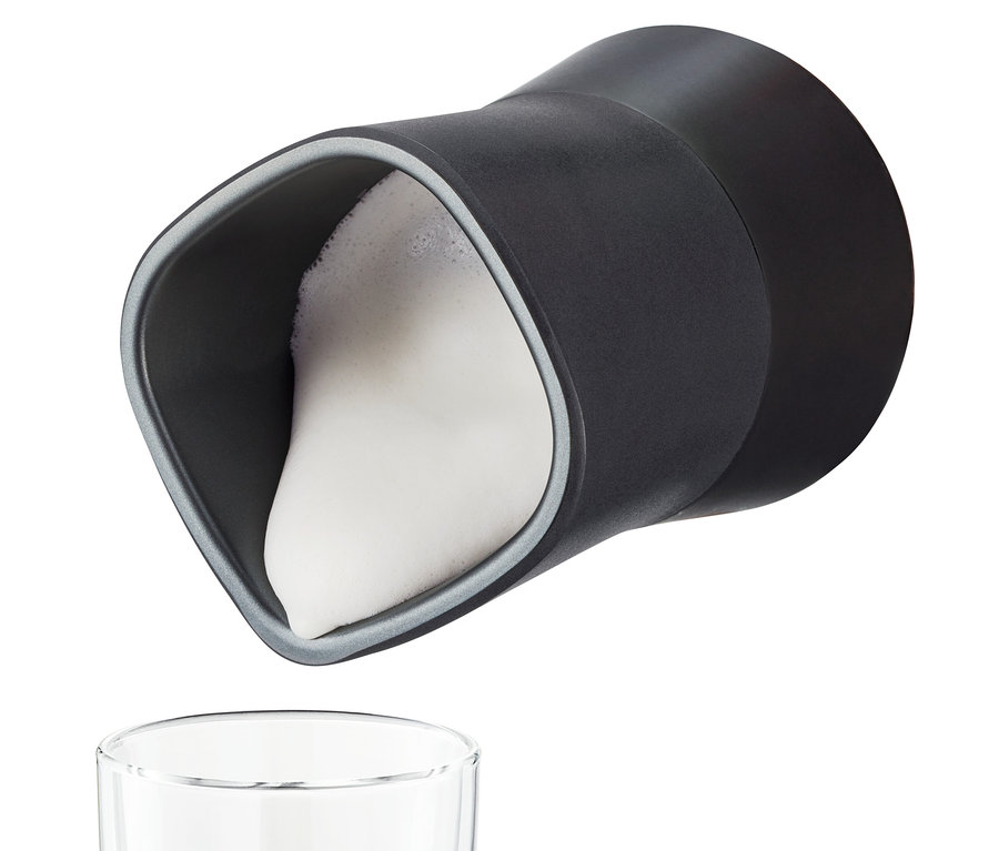 Schwarzer elektrischer Milchaufschäumer gießt Milchschaum in ein Glas.