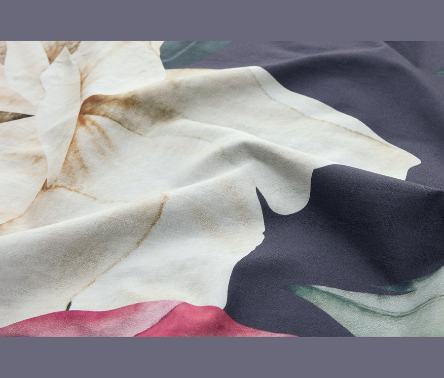 Drapierter Stoff mit großem, abstraktem Blumenmuster in Creme, Braun, Dunkelblau, Grün und Rosa.