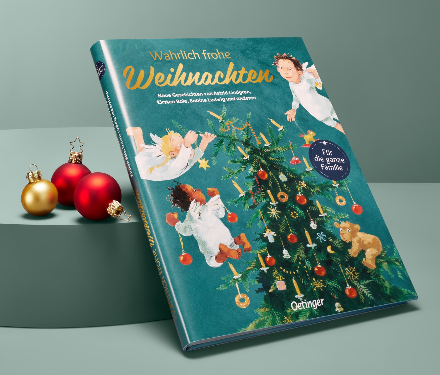 Buch »Wahrlich frohe Weihnachten« liegt neben drei Weihnachtskugeln.