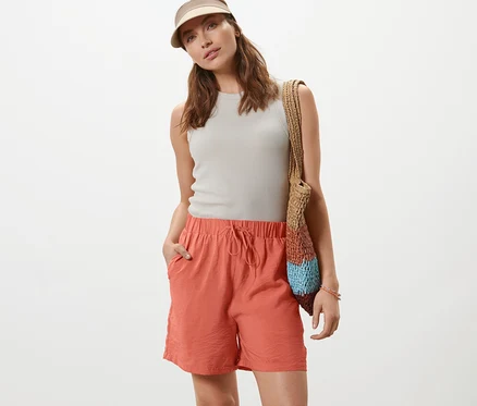 Frau posiert in apricotfarbenen Shorts.