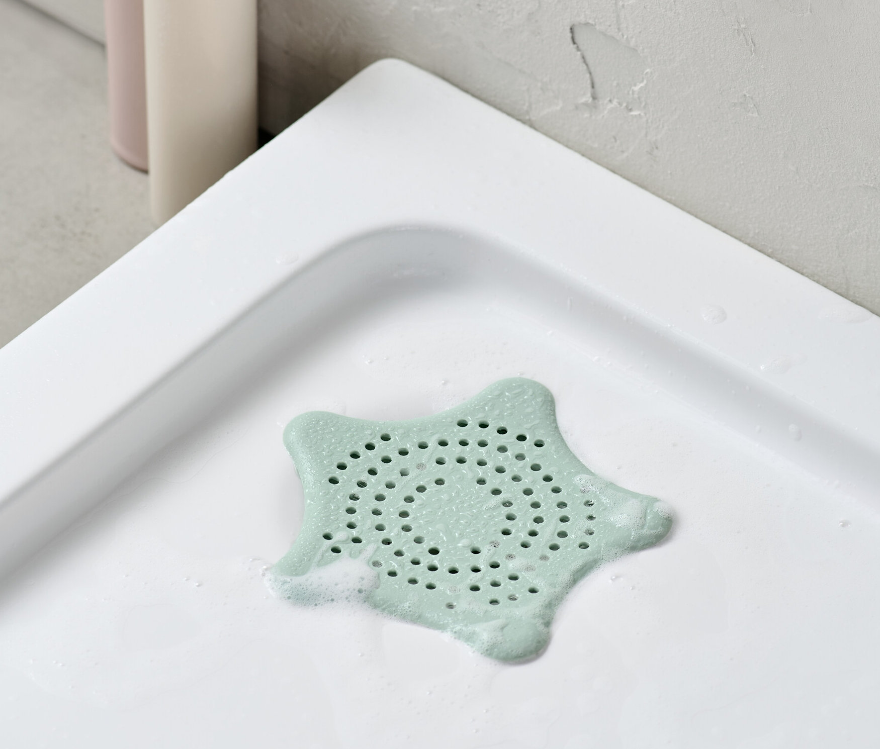 Ein Abflusssieb liegt in einer Duschwanne.