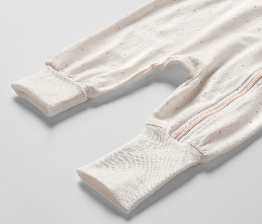 Detailansicht eines Baby-Pyjamas mit rosa Punkten und Reißverschluss. Produkt: 3 Baby-Pyjamas, Prinzessin.