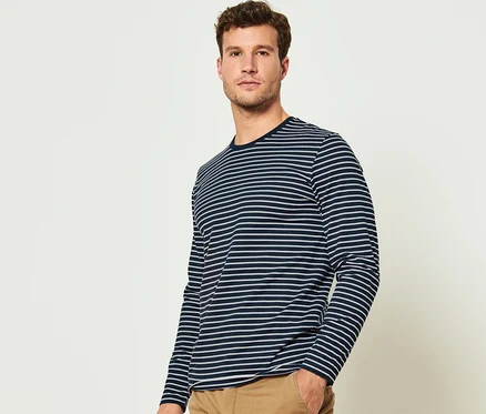 Mann posiert und trägt eines von zwei Langarmshirts aus dem Set.
