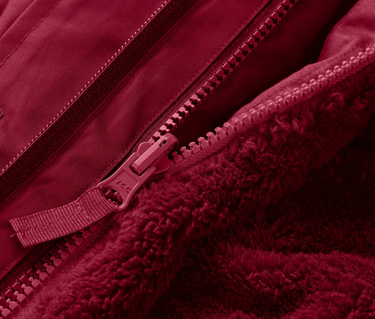 Detailaufnahme einer roten 3-in-1-Kinderwinterjacke mit Reißverschluss.