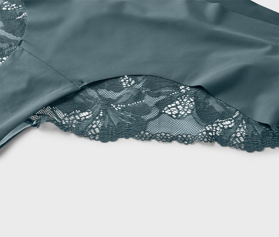 Detailaufnahme eines türkisfarbenen Stoffes mit türkisfarbener Spitze.