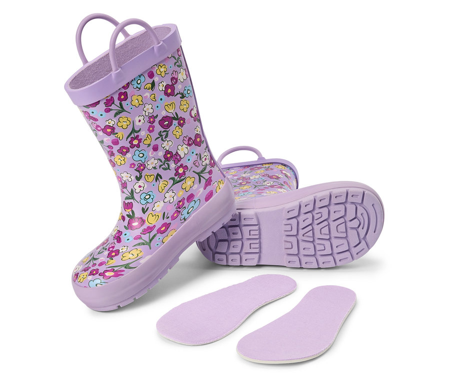 Lila Gummistiefel mit Blumenmuster und Einlegesohlen liegen auf einem weißen Hintergrund.