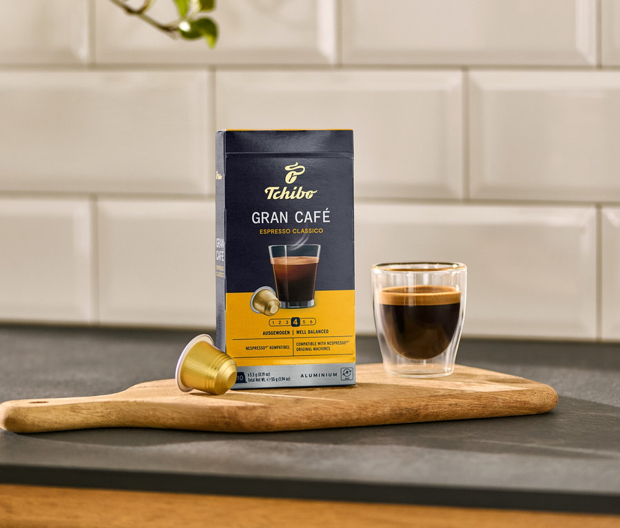 Eine Packung und eine Tasse Gran Café Espresso Classico stehen auf einem Holzbrett.