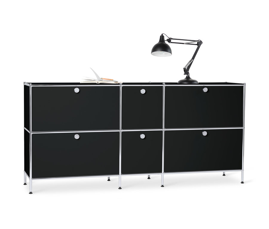 Schwarzes Sideboard Metall »CN3« groß mit 6 Klappenfächern. Auf der Oberseite liegen ein offenes Buch und eine Lampe.