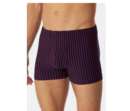 Mann trägt dunkelblaue SCHIESSER Shorts mit roten Streifen und Bio-Baumwolle.