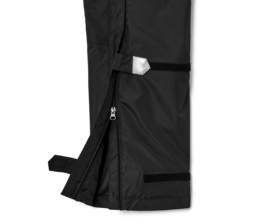 Detailaufnahme einer schwarzen Unisex-High-Tech-Regenhose mit geöffnetem Reissverschluss an der Seite.