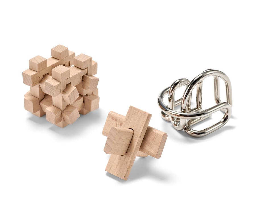 Drei Geschicklichkeitsspiele auf weißem Hintergrund. Zwei aus Holz und eines aus Metall.
