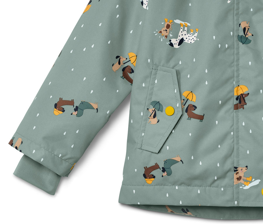 Detail einer Kinder Thermo-Regenjacke mit Hunde- und Tropfenmuster.