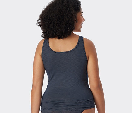 Rückansicht einer Frau mit dunklem lockigem Haar in einem dunkelblauen SCHIESSER Trägertop mit Streifen.