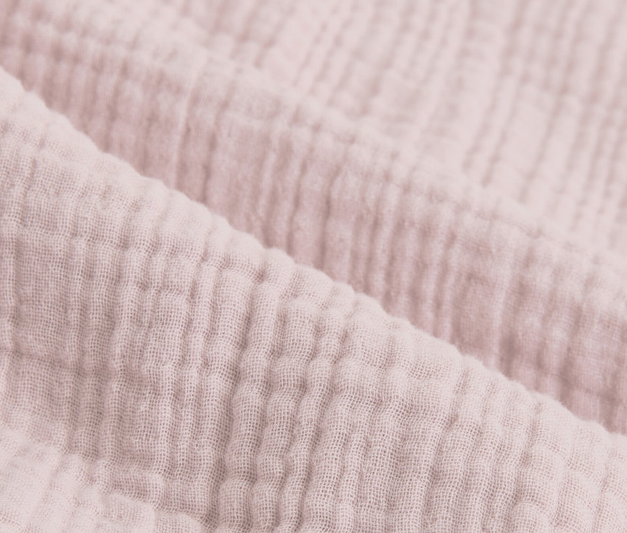 Nahaufnahme von rosafarbener Musselin-Bettwäsche.