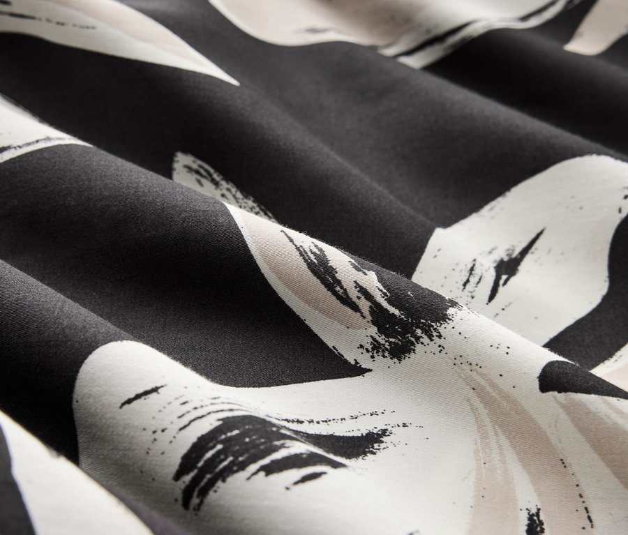 Detailaufnahme eines schwarz-weissen Stoffes mit Blumenmuster.