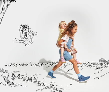 Ein Mädchen trägt einen Jungen Huckepack und beide laufen durch eine gezeichnete Landschaft. Das Mädchen trägt ein Jeanskleid und rosa Lurchi Sandale »Barefoot«. Der Junge trägt ein gelbes T-Shirt und eine karierte Shorts.