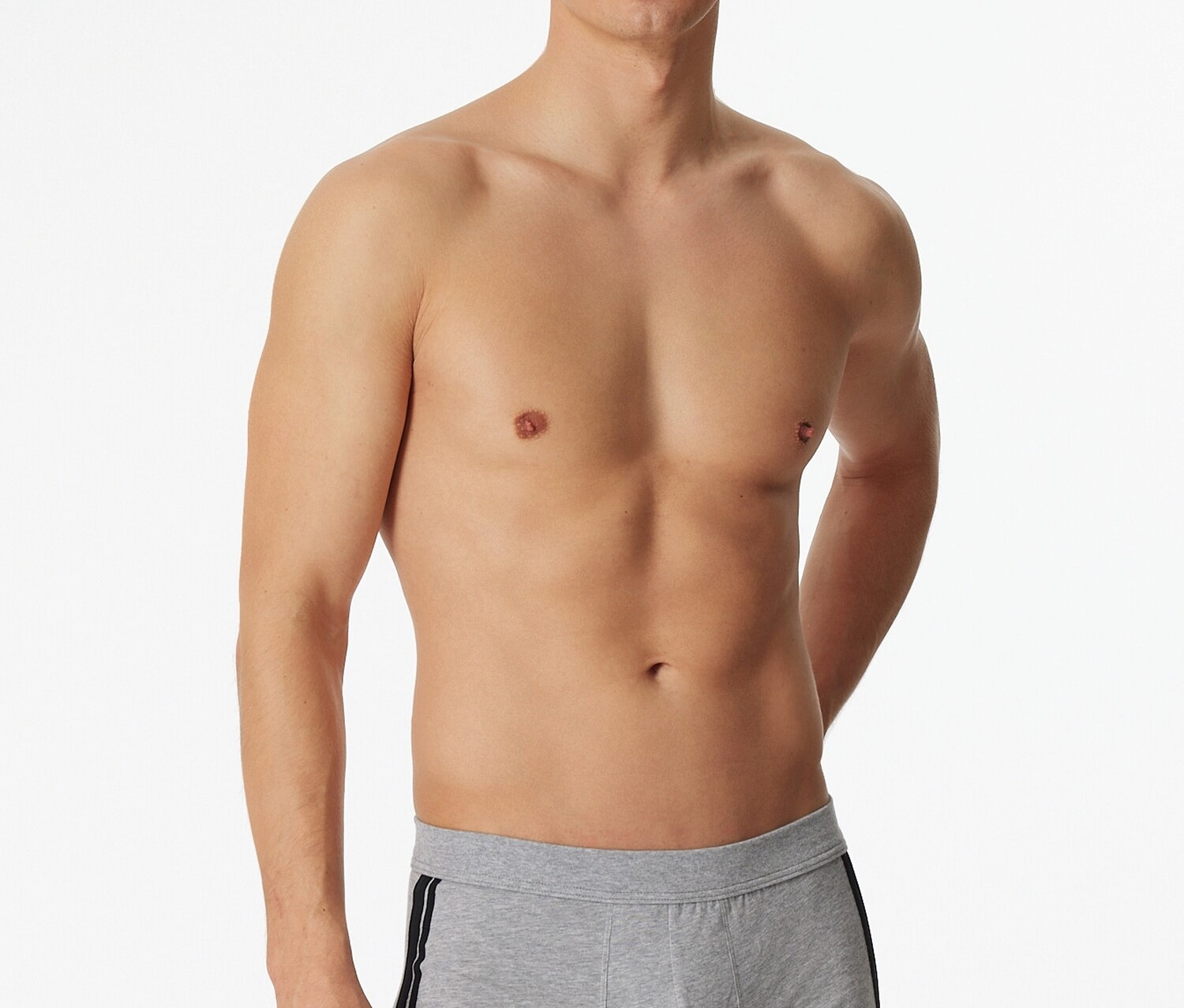 Mann posiert barfuß in hellgrauen SCHIESSER Shorts mit Melange-Effekt und schwarzem Seitenstreifen.