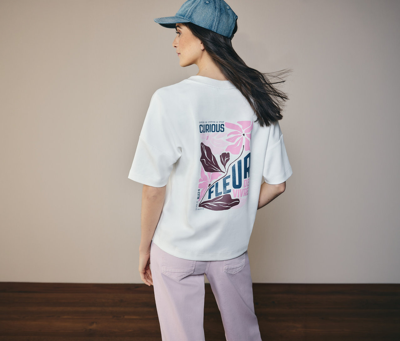 Frau von hinten mit Jeansjacke und CECIL Sweatshirt mit Blumenmuster auf dem Rücken.