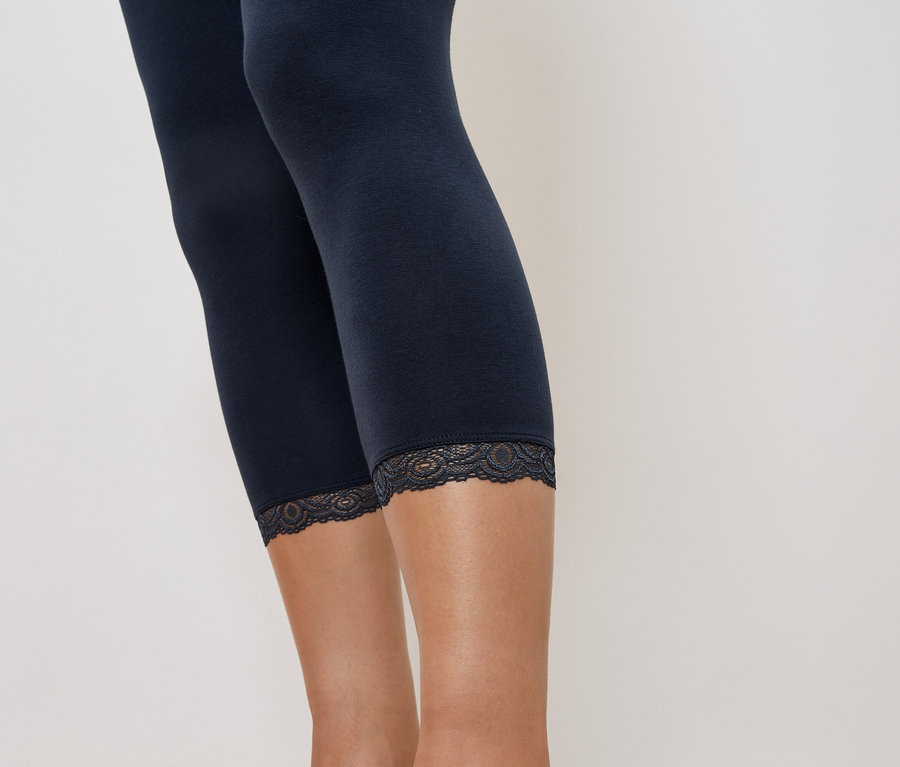 Nahaufnahme von marineblauen Leggings mit Spitzenbesatz am Bein