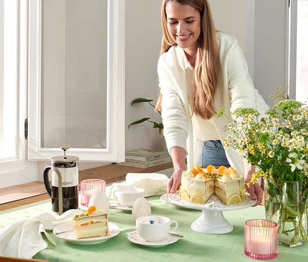 Frau serviert Kuchen neben einer Siebstempelkanne 800 ml, 6 Tassen, champagner.
