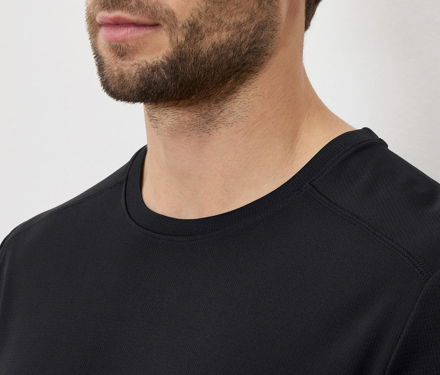 Nahaufnahme eines Mannes mit Bart, der ein schwarzes T-Shirt trägt.