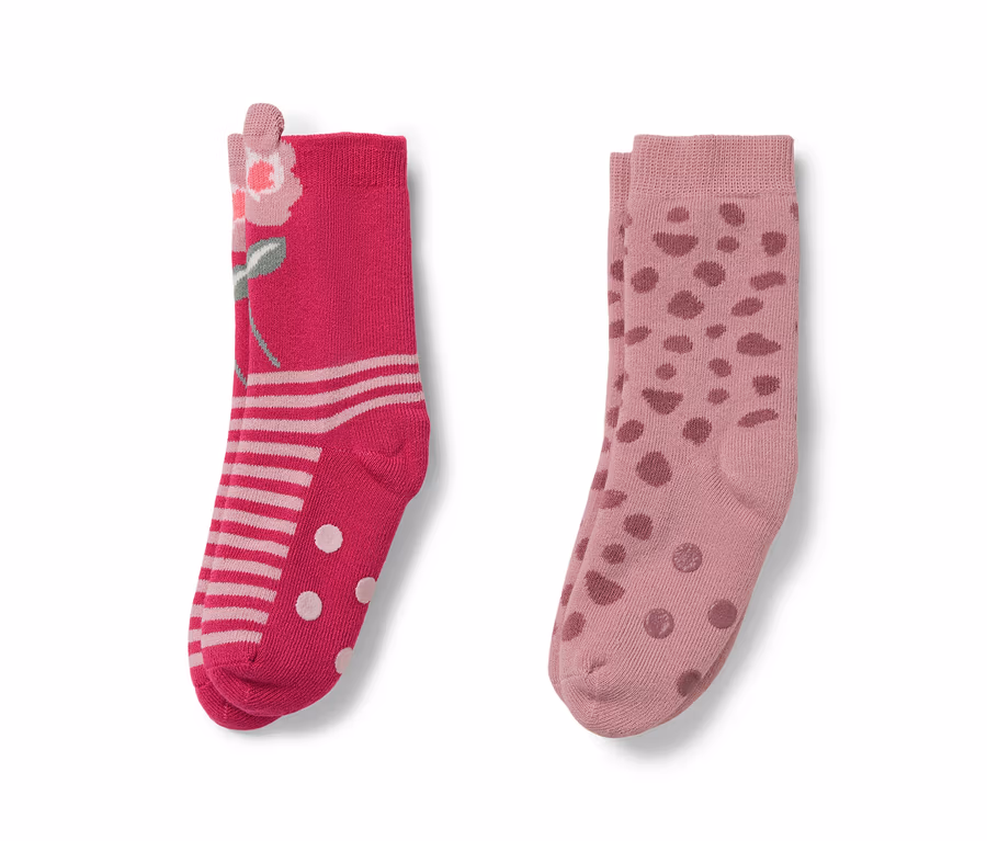 Zwei Paar Socken. Ein Paar rosa mit Blumenmuster, das andere hellrosa mit Punkten.