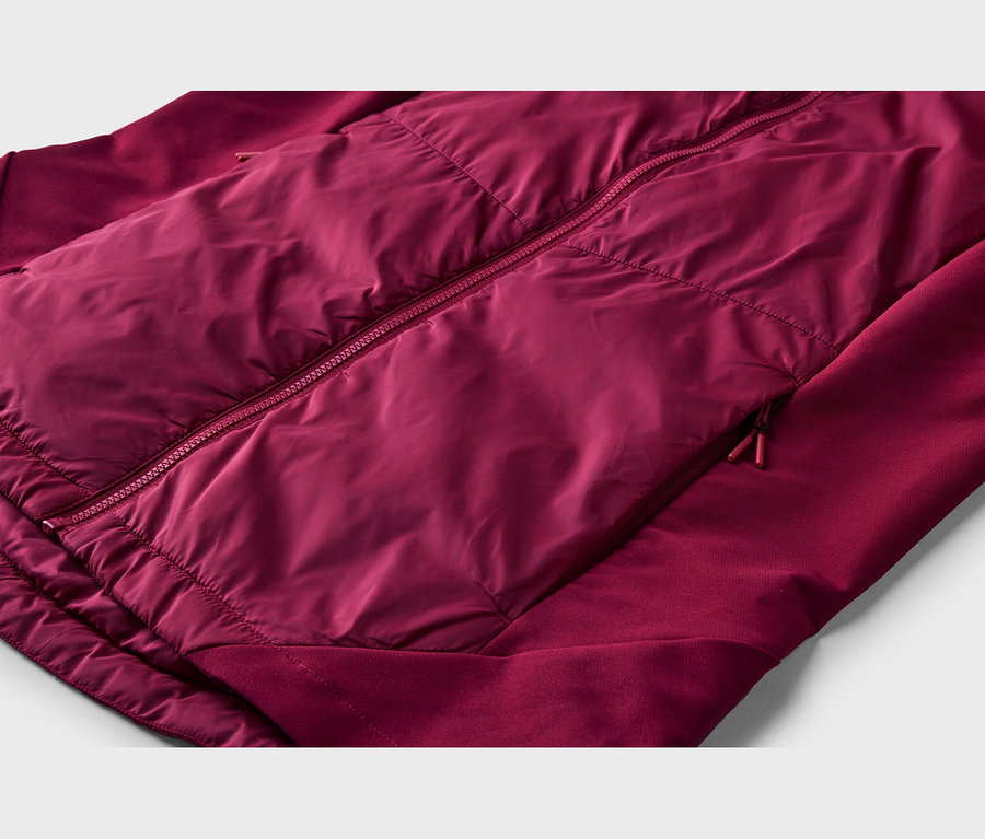 Nahaufnahme einer bordeauxroten Jacke mit einer gepolsterten, glänzenden Vorderseite und matten Ärmeln. Sie hat einen zentralen Reißverschluss und eine seitliche Reißverschlusstasche.