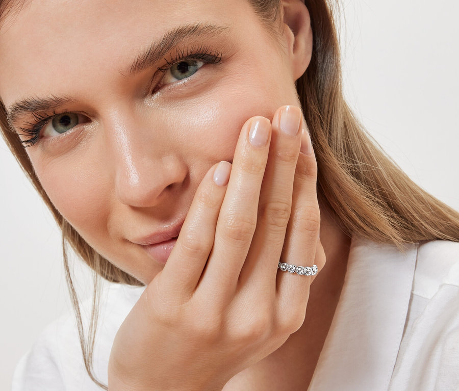 Porträt einer Frau, die einen Ring Memory, chrystal am Ringfinger der linken Hand trägt.