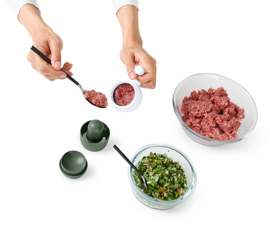 Person verwendet Knödel-und-Fleischbällchen-Former. Zwei Schüsseln mit Fleisch und Gemüse.