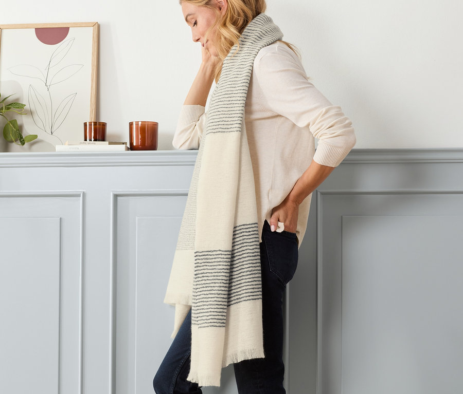 Frau posiert mit gestreiftem Webschal.