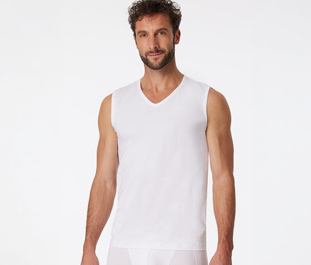 Mann trägt ein weißes SCHIESSER Tanktop mit V-Ausschnitt und weiße Slips.