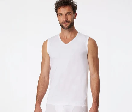 Mann trägt ein weißes SCHIESSER Tanktop mit V-Ausschnitt und weiße Slips.