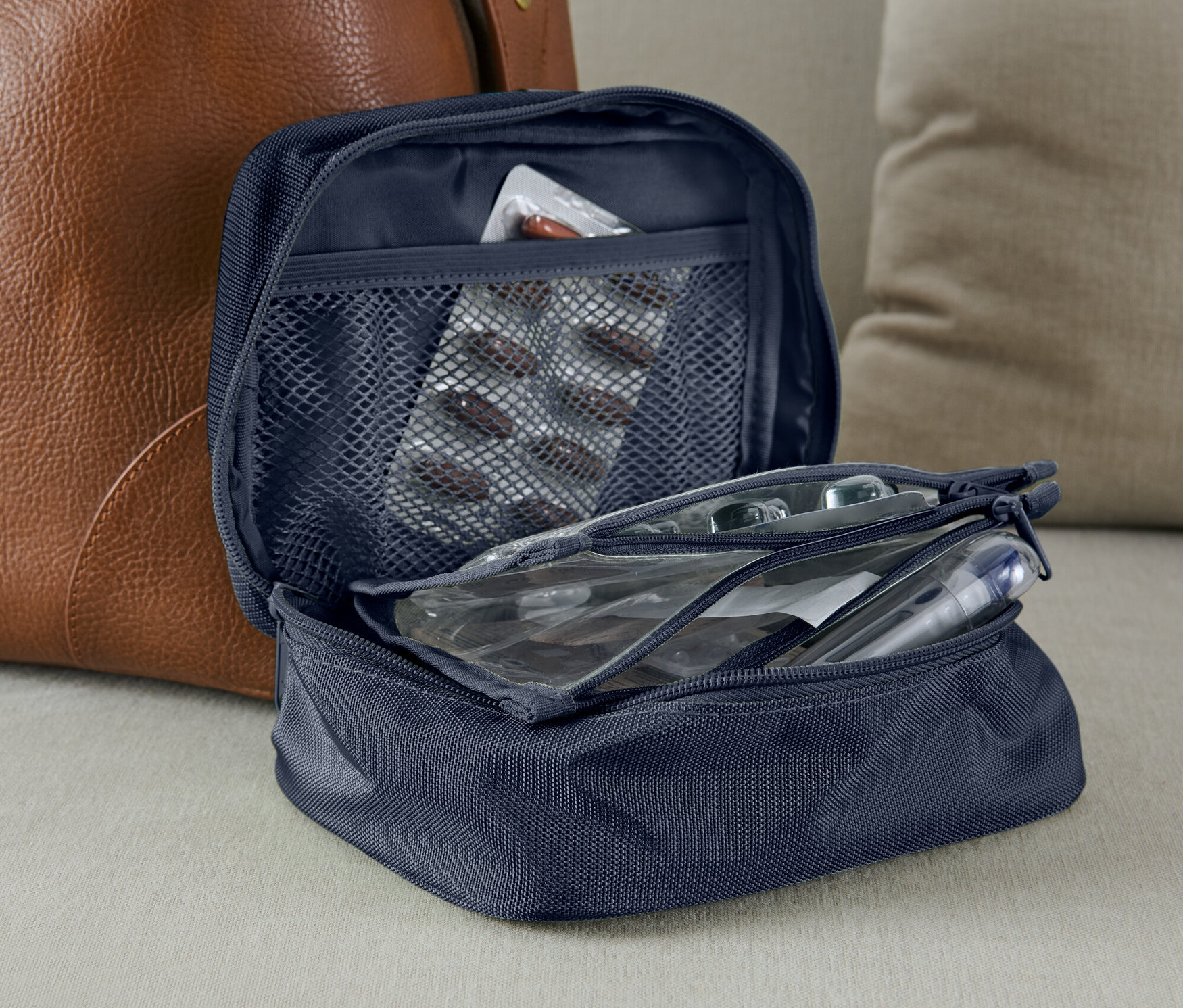 Geöffnete blaue Medikamenten-Tasche mit einer Medikamentenpackung in der Netztasche.