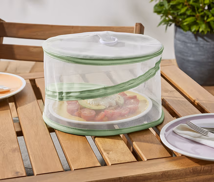 Eine faltbare Mini-Abdeckhaube steht auf einem Holztisch und schützt einen Teller mit Essen.