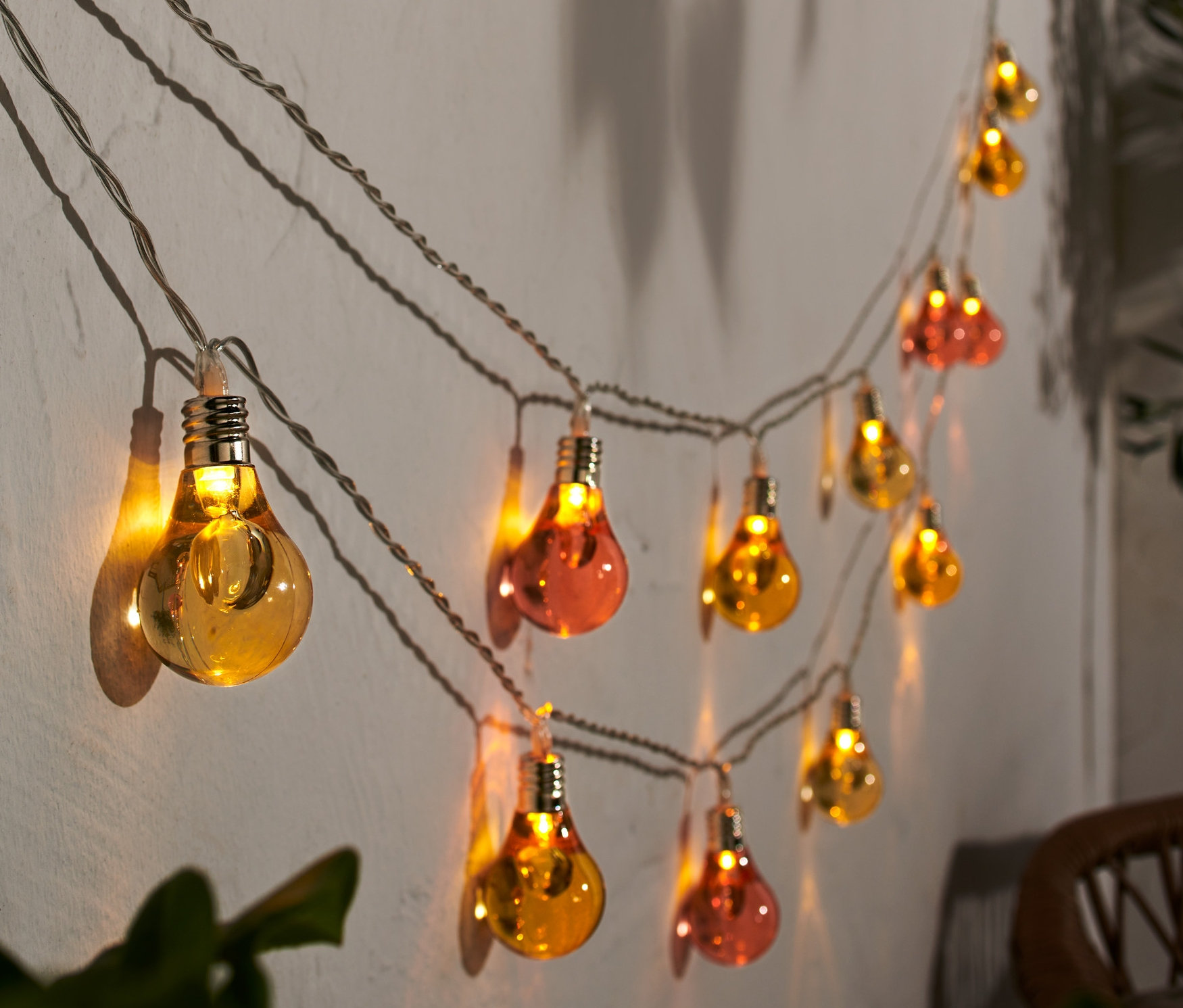 LED-Lichterkette mit Glühbirnen an einer Wand.